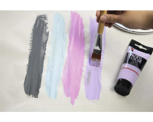 Aufgetragenes Farbmuster mit Acrylfarbe, Pinsel und Farbtube.