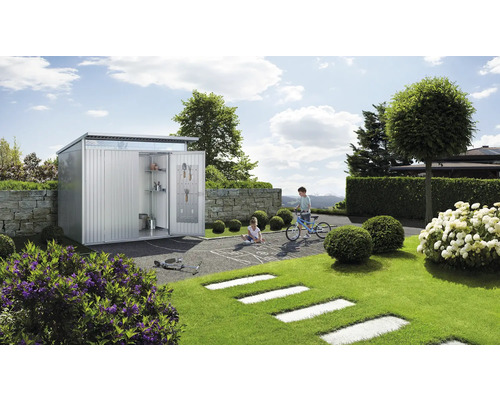 Gartenszene mit Metallgerätehaus, spielenden Kindern und Gartengeräten