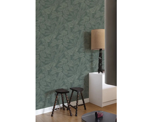 Wohnraum mit gemusterter Tapete, zwei Hockern und Lampe