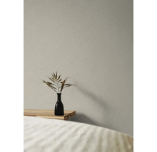 Papier peint décoratif avec structure en lin dans une chambre à coucher avec vase et plante sur la table de chevet