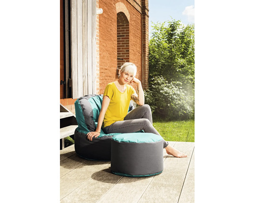 Femme assise dans un fauteuil avec repose-pieds à l''extérieur