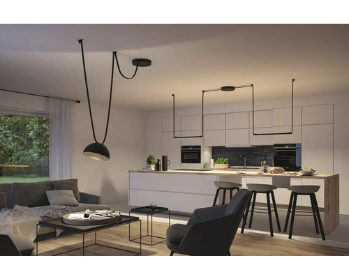 Salon lumineux avec cuisine ouverte et suspensions modernes.