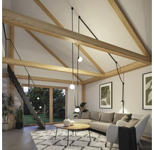 Salon lumineux avec poutres en bois, canapé d''angle, tapis et escalier