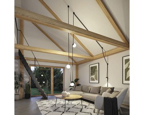 Salon lumineux avec poutres en bois, canapé d''angle, tapis et escalier