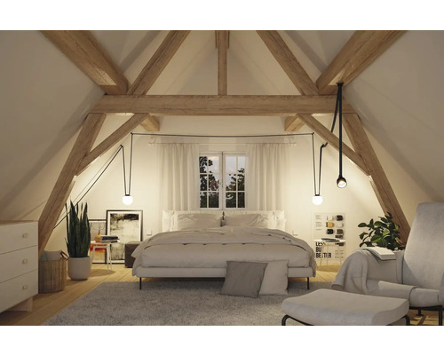 Chambre lumineuse sous les combles avec poutres en bois et suspensions