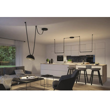 Espace de vie avec suspensions au-dessus de la table à manger et de la table de salon.
