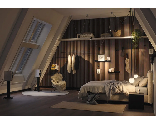 Chambre mansardée avec lit, fenêtre de toit et lambris en bois