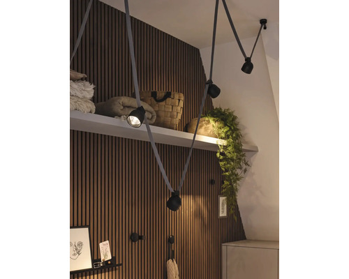 Photo d''intérieur d''une pièce avec des panneaux en bois, une étagère et un plafonnier flexible avec plusieurs spots.