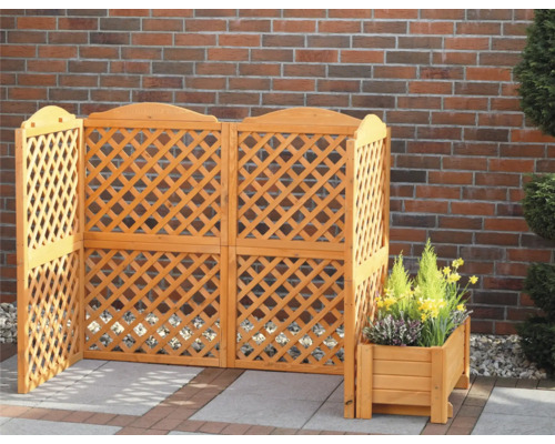 Brise-vue en bois à motif losanges et jardinière devant un mur de briques