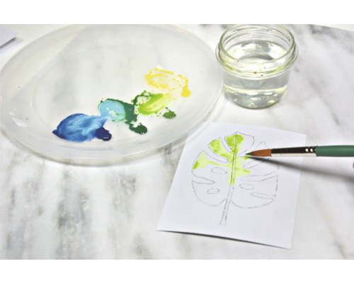 Aquarellmalerei eines Blattes mit Pinsel, Farbe, Wasser und Palette