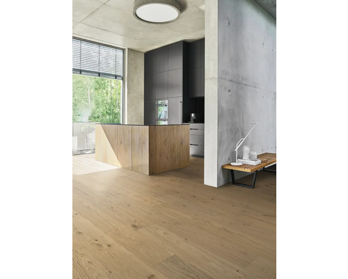Heller Wohnraum mit Holzboden, Kücheninsel und Betonwand