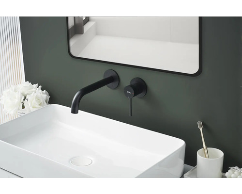 Gros plan d''un lavabo avec robinetterie, miroir et éléments décoratifs dans la salle de bain