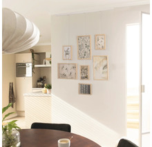 Wohnraum mit Bildergalerie an der Wand und Esstisch