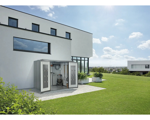 Scène de jardin avec un abri de jardin en métal adossé au mur d''une maison