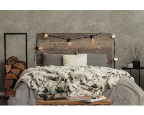 Chambre décorative avec tête de lit en bois, guirlande lumineuse, coussins et couvre-lit