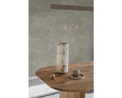 Vase décorative, tasse et sphère sur table en bois devant un mur beige