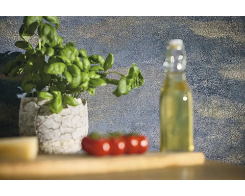 Stillleben mit Basilikumpflanze in einem Topf, Tomaten und einer Flasche Öl auf einem Holztisch.