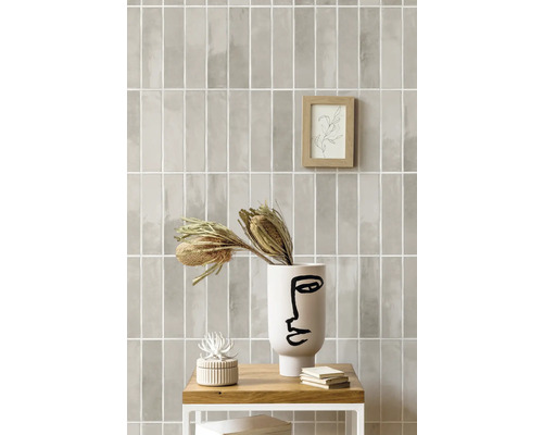 Aménagement mural avec des carreaux rectangulaires dans une teinte claire