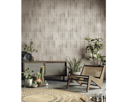 Salon avec carrelage mural marron, armoire en bois, fauteuil et plantes d''intérieur