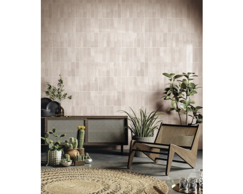 Salon avec mur carrelé, commode, fauteuil et plantes