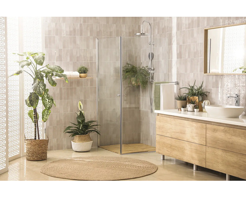 Salle de bain lumineuse avec douche, lavabo, miroir et plantes