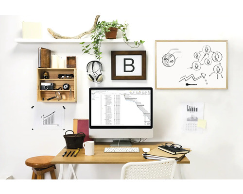 Bureau avec un bureau, un ordinateur, un tableau blanc et des objets de décoration pour une ambiance organisée et lumineuse