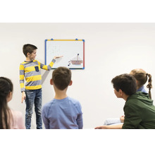 Kind präsentiert Tafel mit Magneten vor Klasse