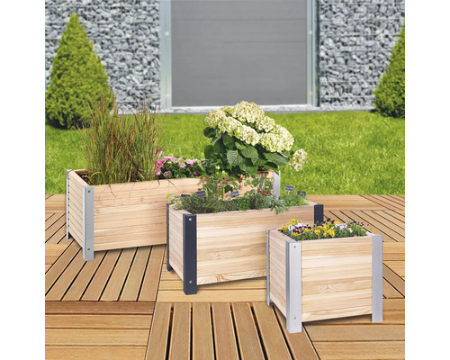 Trois jardinières en bois avec des plantes et des fleurs sur une terrasse