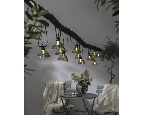 Guirlande lumineuse décorative avec plusieurs lampes au-dessus d''une table avec des chaises