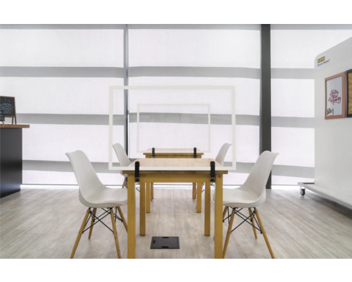 Pièce avec tables, chaises et cadres de protection pour la distanciation sociale