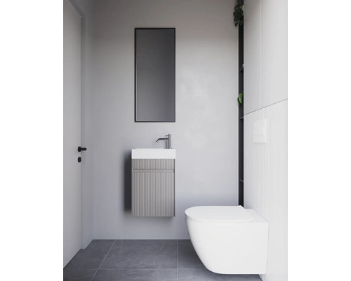 Salle de bain avec lavabo, miroir et toilettes au design moderne