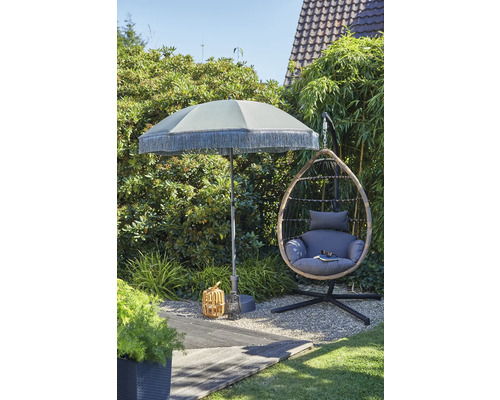 Scène de jardin avec parasol, fauteuil suspendu en rotin et décoration