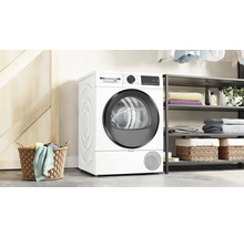 Buanderie blanche avec sèche-linge Bosch, étagère de rangement et panier à linge.
