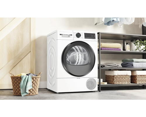 Buanderie blanche avec sèche-linge Bosch, étagère de rangement et panier à linge.