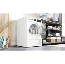 Sèche-linge blanc avec porte ouverte dans une pièce lumineuse