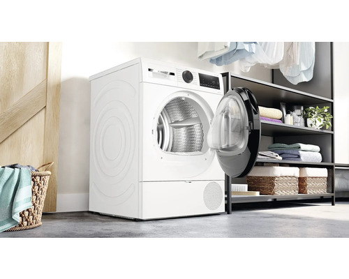 Sèche-linge blanc avec porte ouverte dans une pièce lumineuse