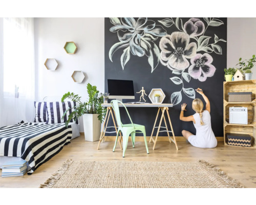 Helles Zimmer mit Kreidezeichnung an der Wand, Schreibtisch und Dekorationen