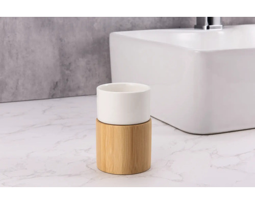 Gobelet à brosse à dents en bambou et céramique devant un lavabo