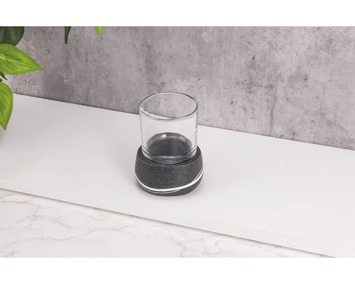 Photophore en verre avec base en pierre sur une surface blanche