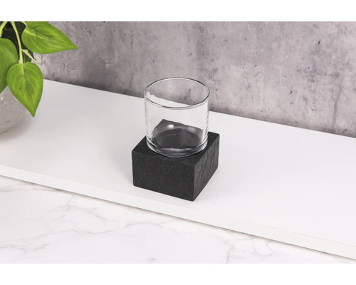 Klares Glas auf schwarzem Steinsockel