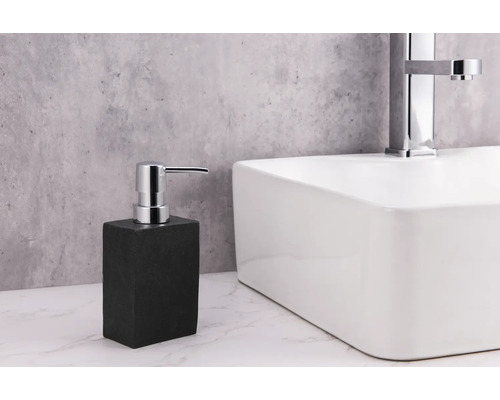 Distributeur de savon en pierre à côté d''un lavabo avec robinet