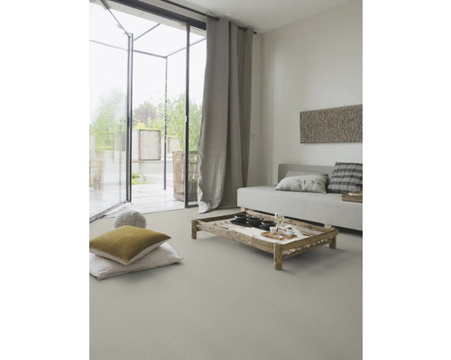 Wohnzimmer mit Sofa, Holztisch, Kissen und Vorhängen für ein helles und freundliches Ambiente.