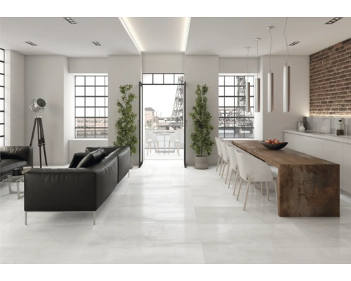 Heller Wohnraum mit schwarzer Ledercouch, Esstisch und großen Fenstern