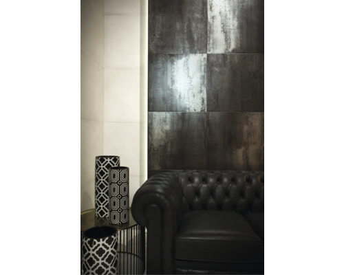 Wohnzimmergestaltung mit dunklen Wandfliesen, einem schwarzen Ledersofa und dekorativen Vasen