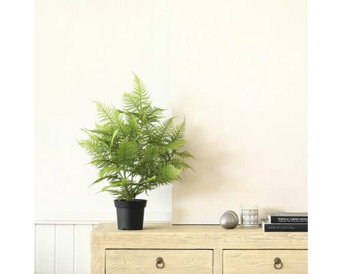 Fougère artificielle en pot sur une commode