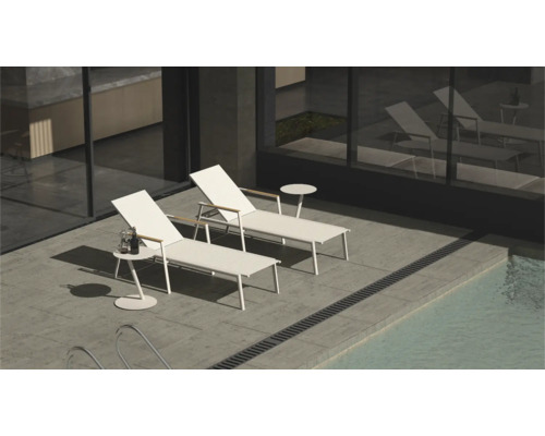 Deux chaises longues blanches et tables d'appoint au bord de la piscine