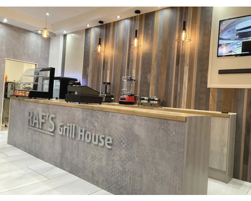 Innenaufnahme eines Restaurants mit Theke, Lampen und Dekoration