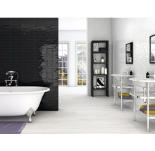 Badezimmer mit freistehender Badewanne, schwarzen und weißen Wandfliesen, Regal und Waschbecken
