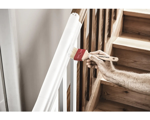 Une personne peint une rampe d''escalier avec un pinceau.