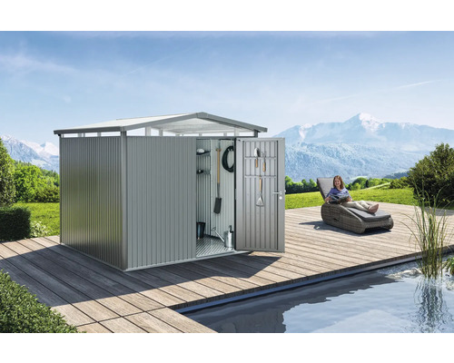 Armoire de jardin en métal avec porte ouverte, outils et une femme sur une chaise longue à côté d''un étang